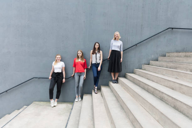 istock Young women standing on stairs by concrete wall 824956722