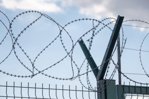 istock Safe protective metal fence with barbed wire 824959594