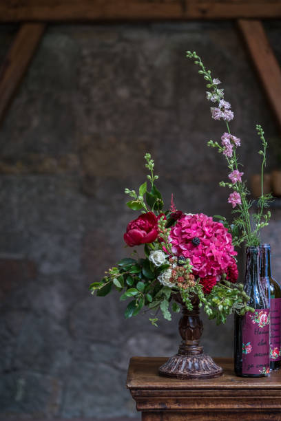 istock Wedding peony bouquet with wine bottles against vintage dark stone background. Rustic style. 824960104