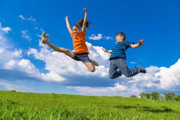 istock Two kids jumping on green hills 824963362