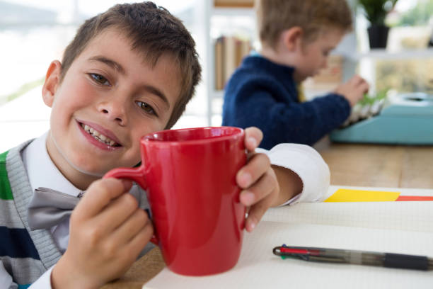 istock Boy as business executive holding coffee mug in office 824966706