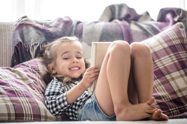 istock little girl reading book on sofa 824968046