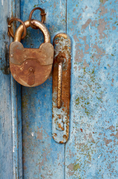 istock Old closed padlock rusty on wooden weathered door 824987690