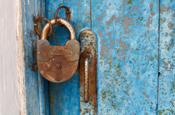 istock Old closed padlock rusty on wooden weathered door 824987724