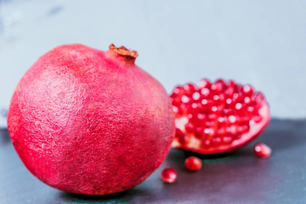 whole and cut pomegranate on dark vintage background  with copy space - usa restaurant flower bed beauty in nature imagens e fotografias de stock