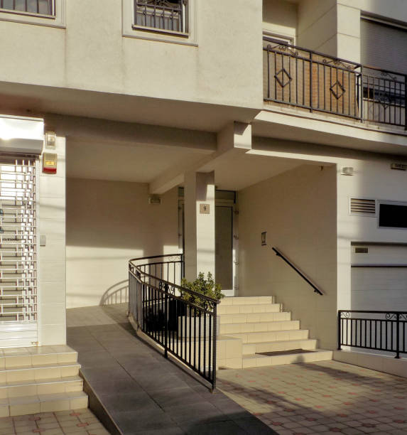 una rampa para silla de ruedas en la entrada de un edificio residencial - vertical ramp fotografías e imágenes de stock