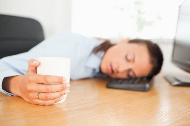 istock Sleeping businesswoman with coffee in office 824995258