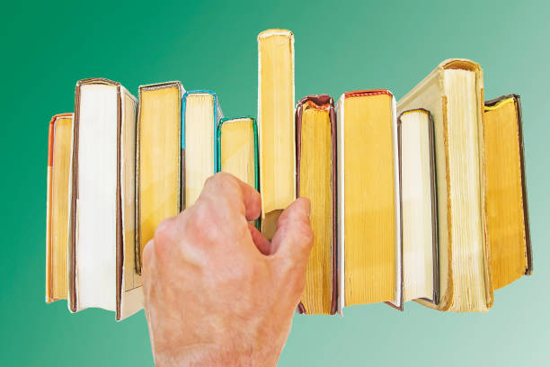 istock hand takes book from shelf 824998306