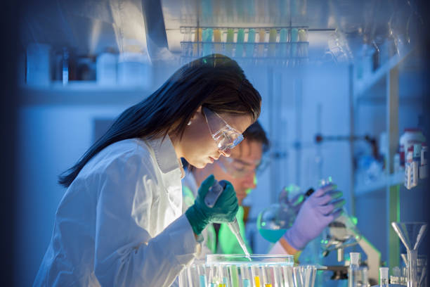 istock Scientist putting liquid into petri dish in lab 825002276