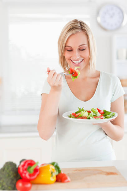 istock Young woman eating salad 825005062