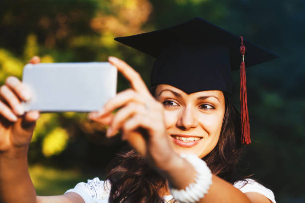 istock Happy graduate girl taking a selfie 825005606