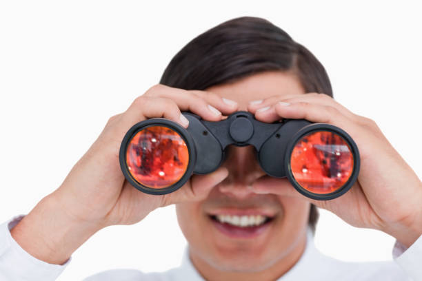istock Close up of smiling young tradesman looking through binoculars 825005922