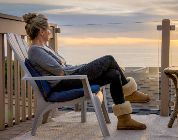 istock Woman watching sunset over the ocean 825005938