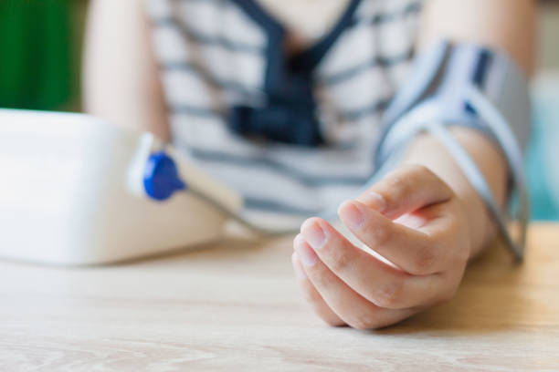 istock Woman using digital blood pressure monitor 825011682