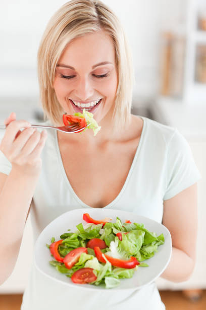 istock Blonde woman eating salad 825015404