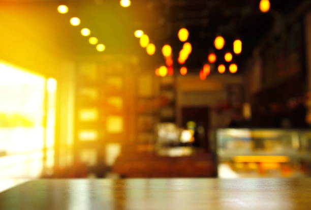 istock wood table with blur cafe or bar interior design with orange light at dark night background 825015786