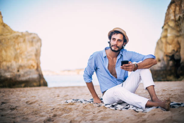 istock Stylish young man relaxing at coastline 825016504