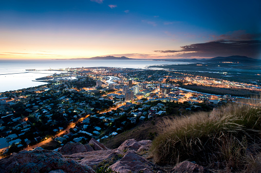 Cityscape of illuminated Townsville and ocean at dusk, Australia