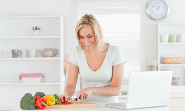istock Young woman cutting peppers 825023430