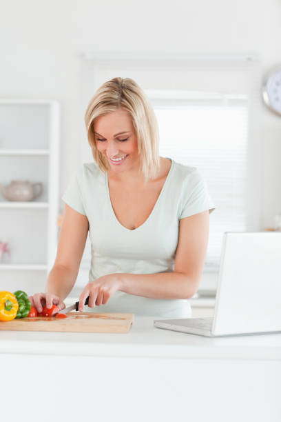 istock Blonde woman cutting peppers 825023500