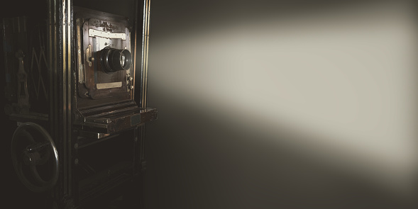 Vintage movie projector with light on gray backdrop use for background or web banner design.