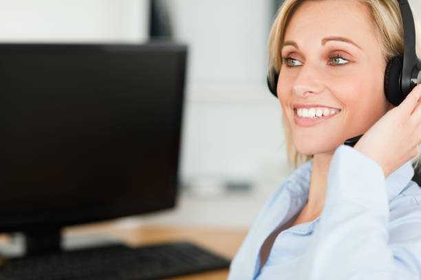 istock Portrait of a smiling businesswoman with headset working with computer looking elsewhere 825030408