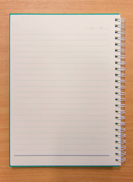 istock Notebook paper with on wooden background 825034860