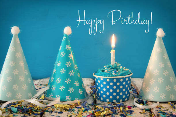 Birthday concept with cupcake and candle on wooden table.