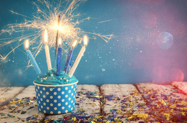 istock Birthday concept with cupcake and candles on wooden table 825035252