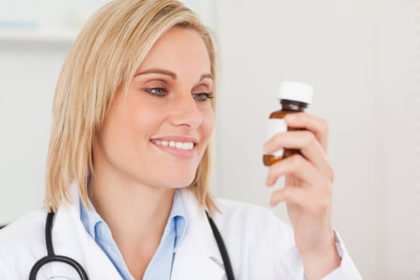 istock Smiling doctor looking at medicine 825037880
