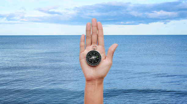 istock Compass in hand against Tropical seascape view. 825045510