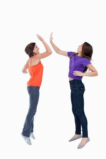 istock Teenagers jumping while giving each other a highfive 825050356