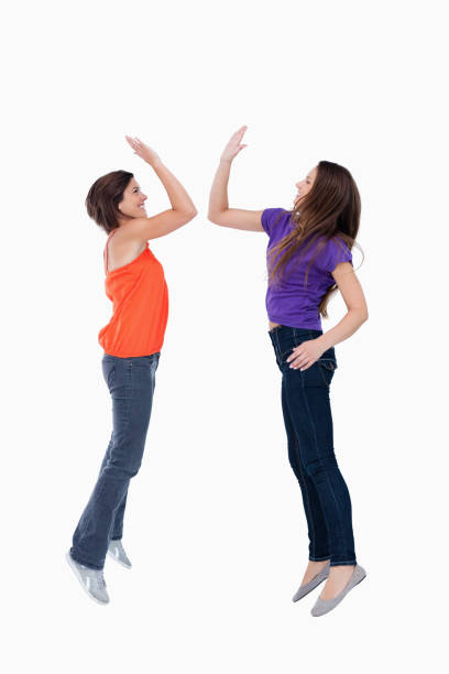 istock Two teenagers which are giving a highfive while jumping 825050390