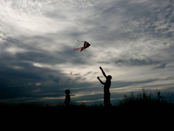 istock father and son flying a kite at wonderful sunset 825059130