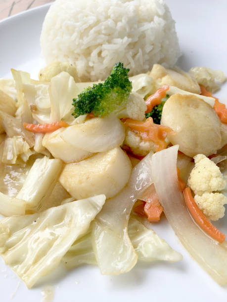 tofu frit avec des légumes dans un plat blanc avec du riz au jasmin thaïlandais sur fond en bois. nourriture de style thaïlandais. nourriture végétarienne. - tofu chinese cuisine vegetarian food broccoli photos et images de collection