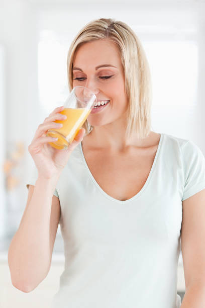istock Charming woman drinking orange juice 825063862