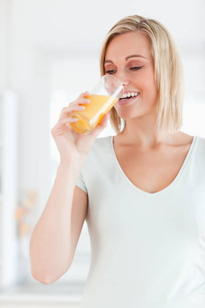 istock Cute woman drinking orange juice 825063874