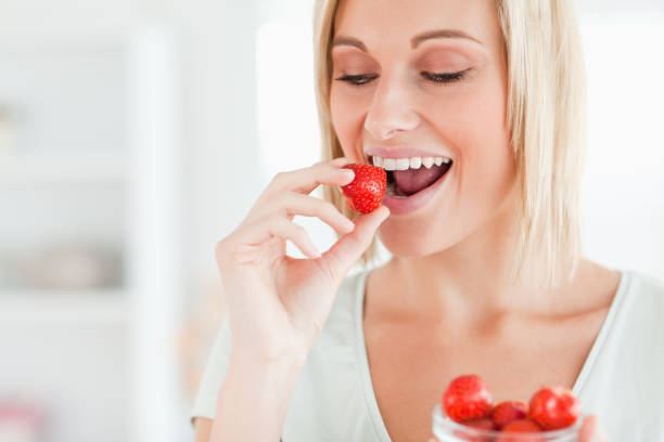 istock Woman enjoying eating strawberries 825064024