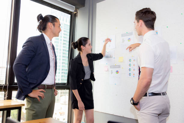 istock three business people in modern office looking report and analyzing with talking in meeting room. 825064348