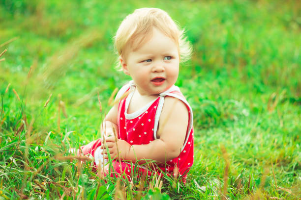 istock The child is sitting on the grass 825071468