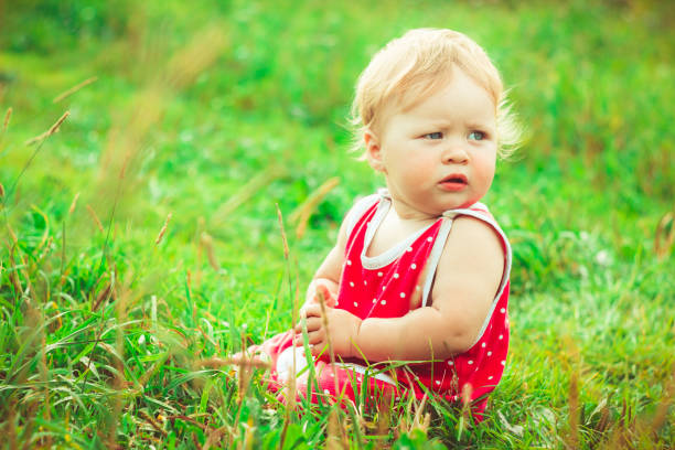 istock The child is sitting on the grass 825071488
