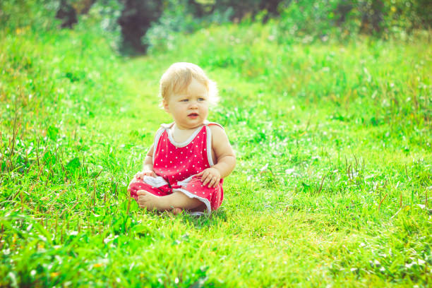 istock The child is sitting on the grass 825071624