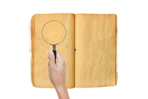白い背景に、古い本の虫眼鏡を持つ手。 - book low scale magnification magnifying glass examining ストックフォトと画像