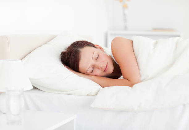 istock Beautiful Redhaired woman lying in bed sleeping 825075026