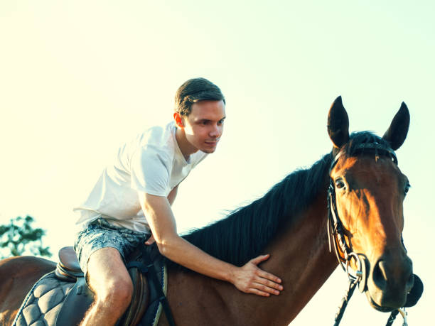 istock Young man embracing his horse. 825078874