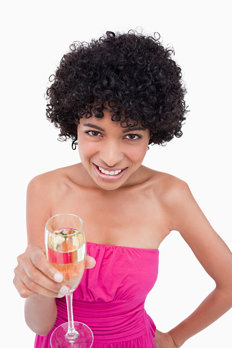Teenager smiling while holding a glass of champagne