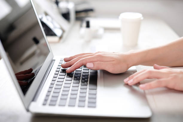 istock Hands of a woman working at a computer 825079824