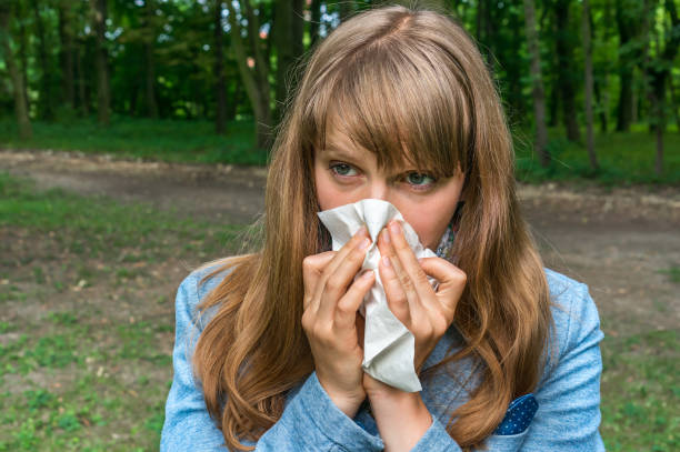 istock Woman with flu or allergy symptoms in park 825091184