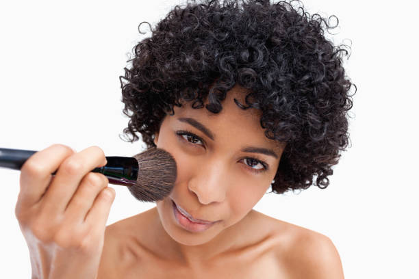 istock Young woman applying natural blush on her face 825091434