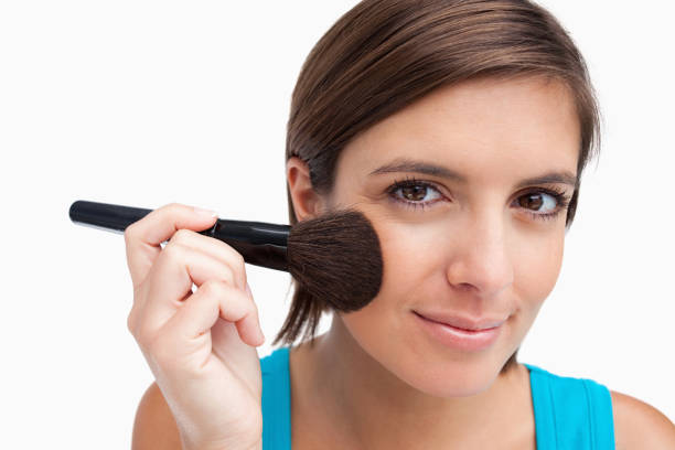 istock Young woman using a black powder brush 825091716